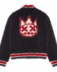 A model shown from the back wearing a black fuzzy jacket with a large red and white crown graphic on the back and red and white striped trim at the collar, hem, and cuffs.