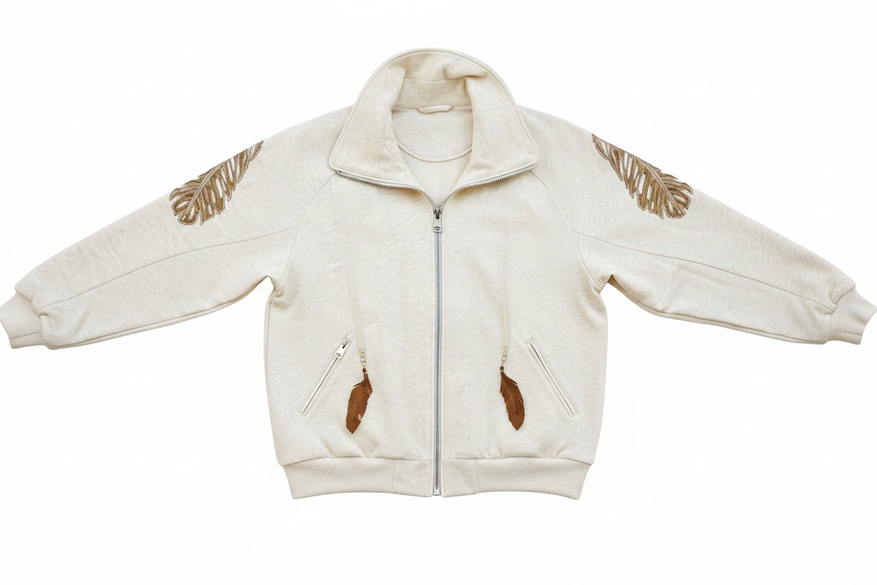 A person wearing a beige 'SLASHED FEATHER' blouson with leather feathers on the hood and sleeves, paired with blue jeans.