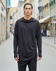 Front-facing model in the black ZHANNAONA Skyline sweater, reframed square with the street background